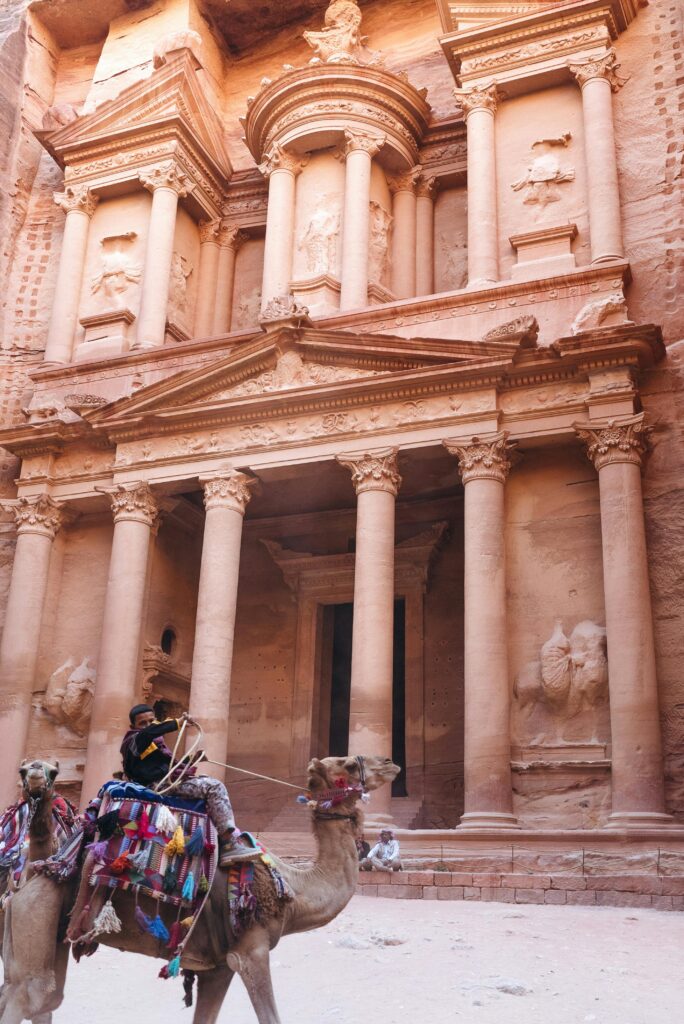 A camel ride in front of Petra's iconic Treasury, showcasing ancient architecture.